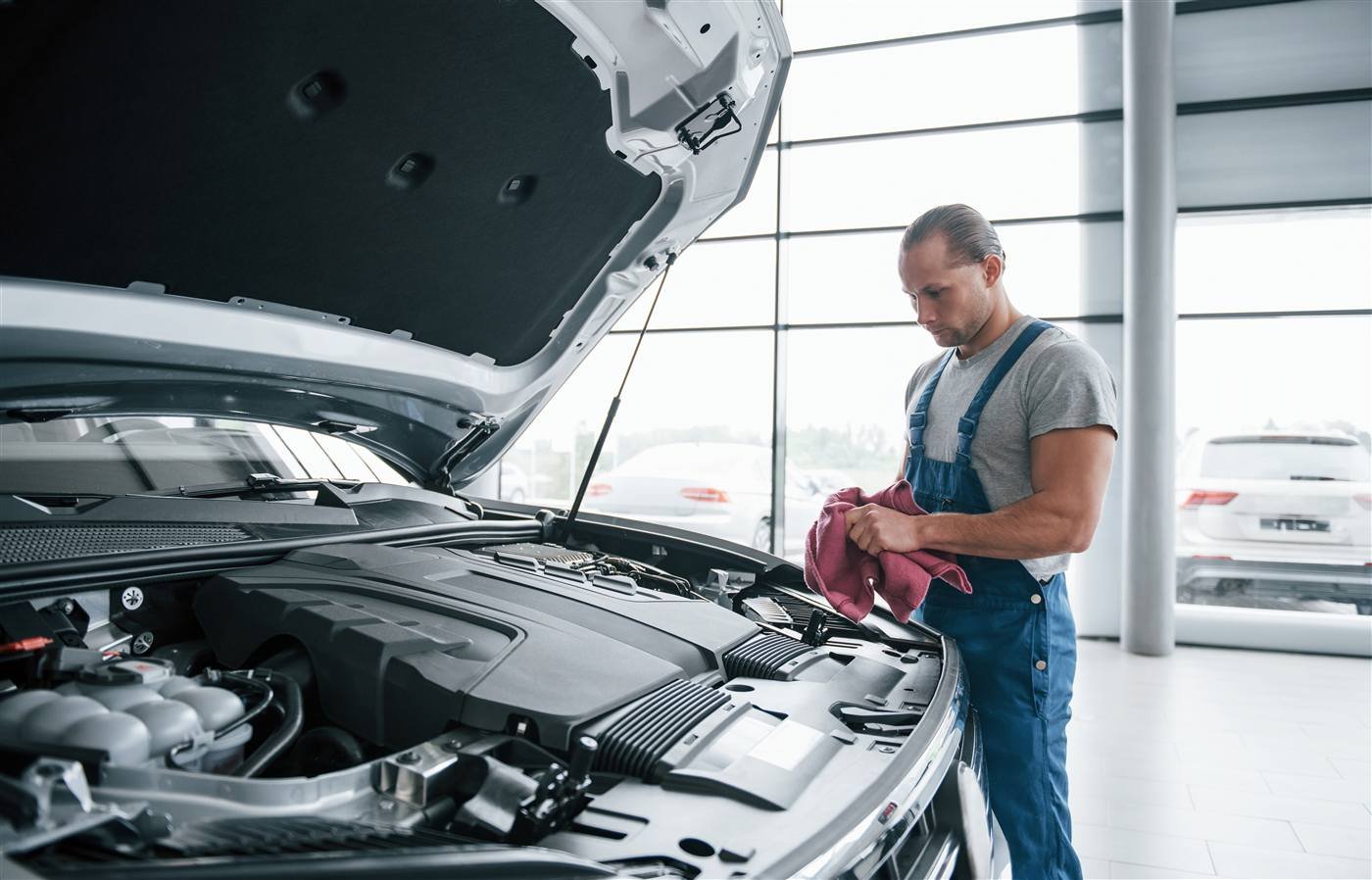 Mecânico especializado finalizando a inspeção do compartimento do motor
